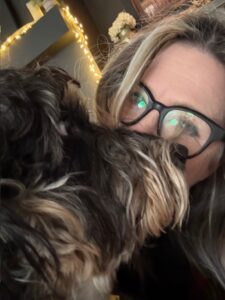 Woman holding her dog close after a health scare, capturing a tender moment of love, relief, and reconnection